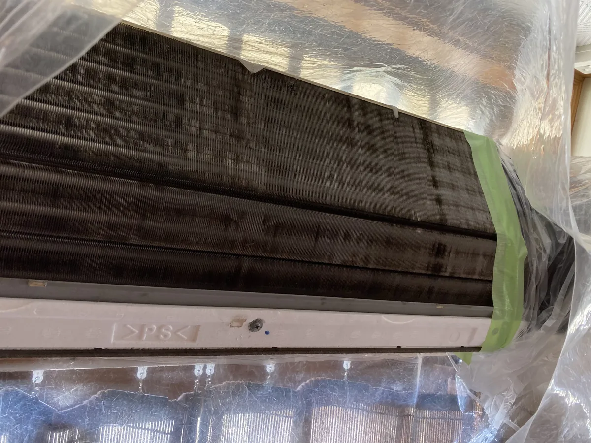 洗浄前のエアコン内部。熱交換器がカビとホコリで真っ黒